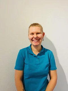 Profilfoto TFA Franziska Schroeder. Sie hat kurze blonde Haare, trägt ein türkisfarbendes Poloshirt.